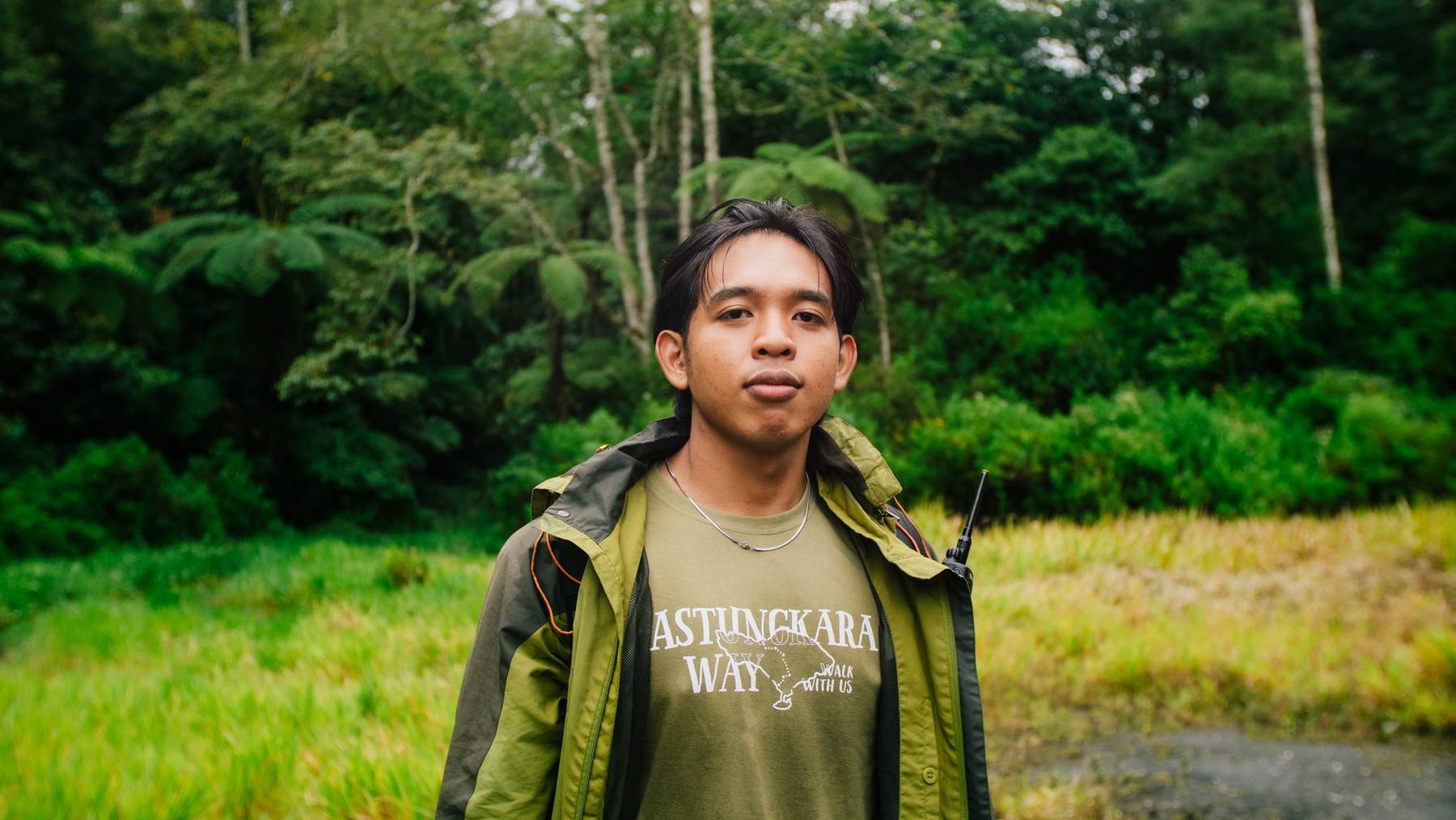 Tona, an Astungkara Way trail guide, standing at the forest edge