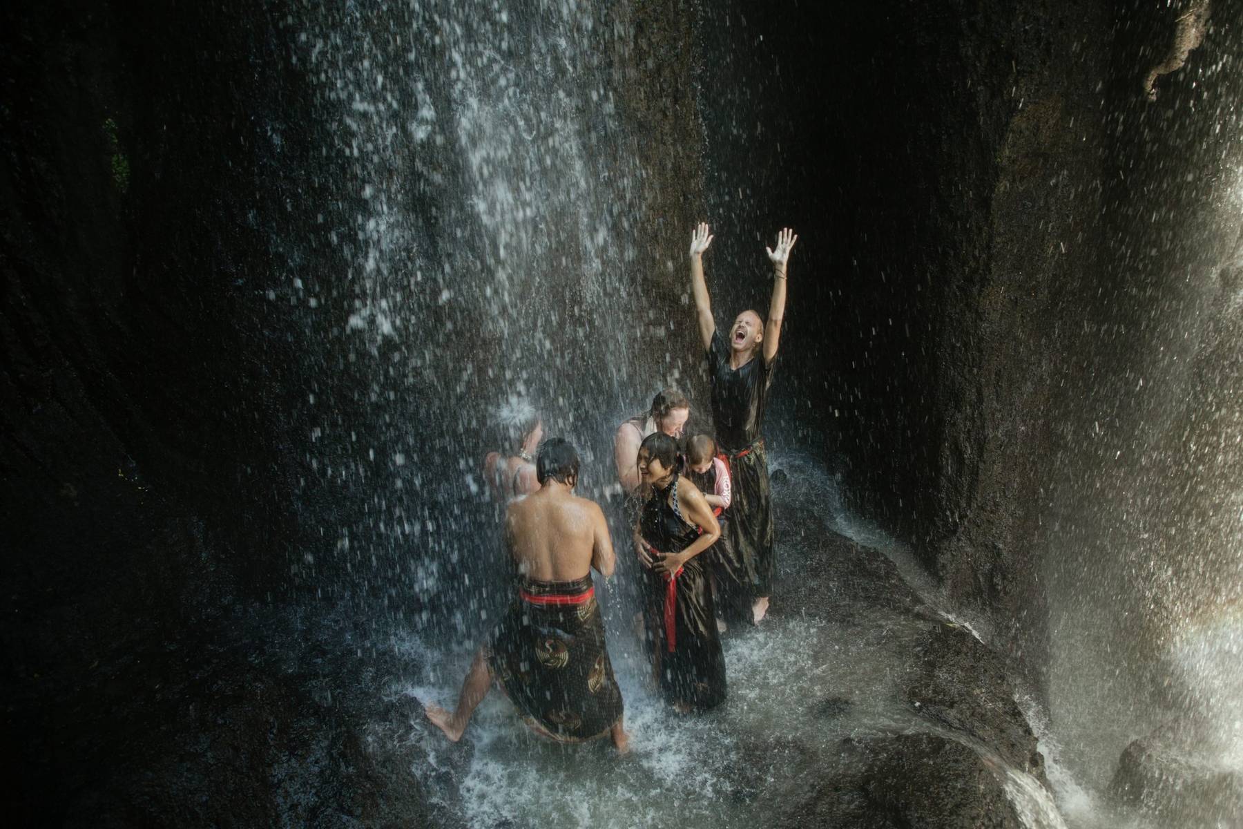 Pilgrims celebrating under a waterfall