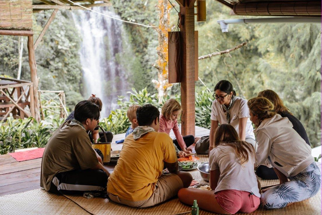 Families preparing lunch together on the platform facing the waterfall