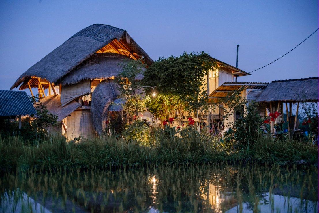Our farm buildings lit up at dusk above a flooded rice field