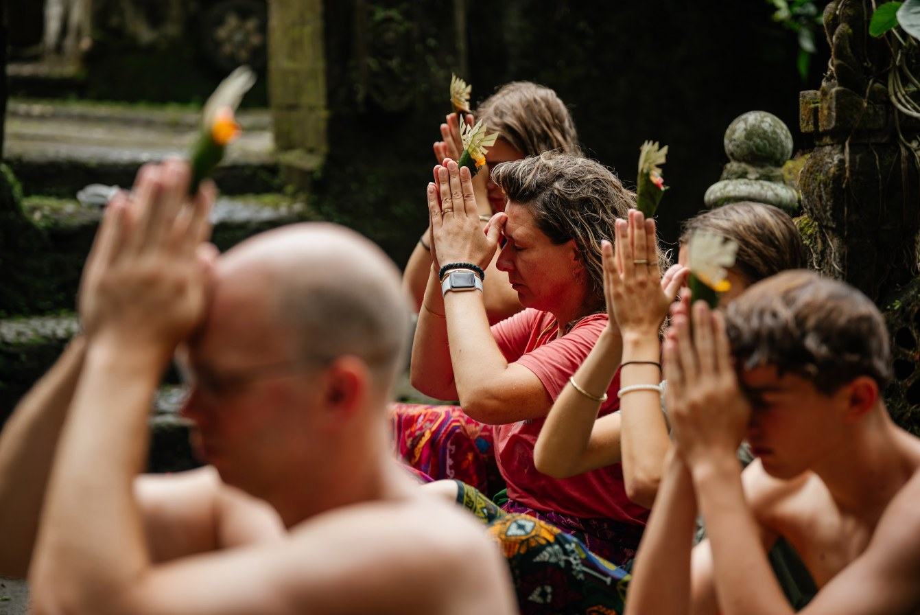 Pilgrims with hands joined in prayer during a water blessing