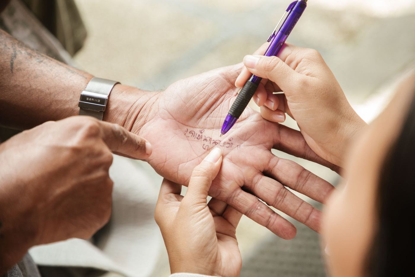 A host writing Balinese script on a pilgrim's palm