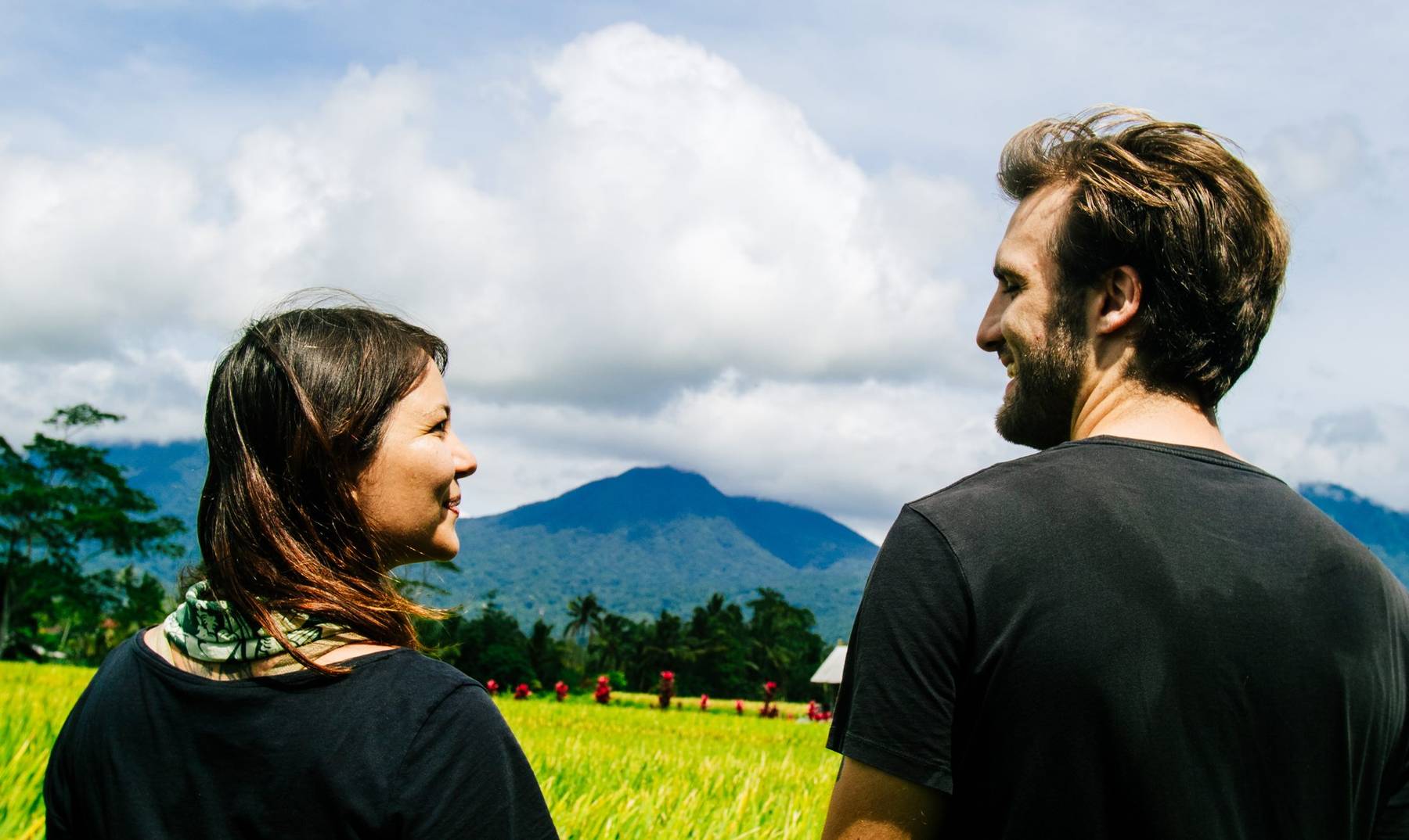 Two pilgrims looking out over the rice fields towards the mountains