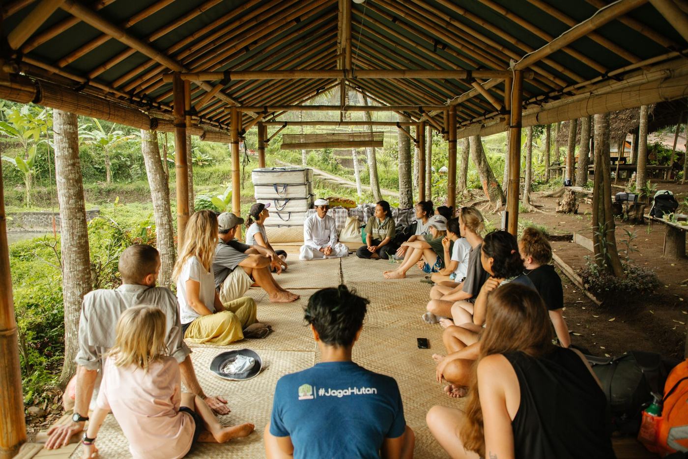 Pilgrims sitting together in a bamboo pavilion on the farm