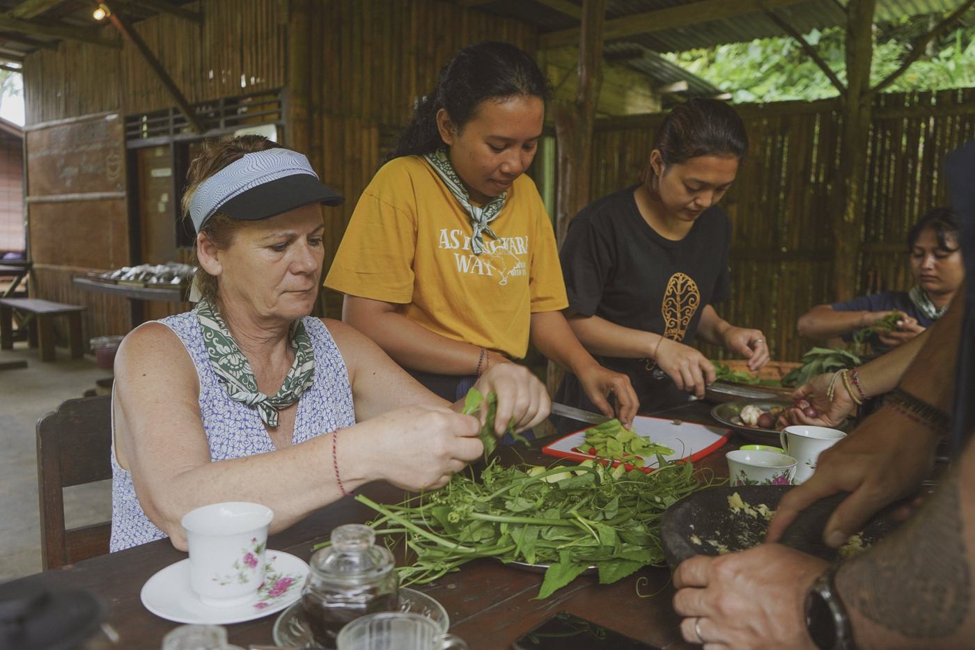 Pilgrims preparing vegetables alongside their host