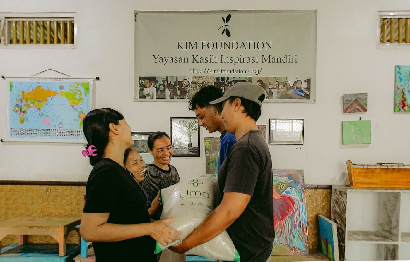 Our team handing a sack of regenerative rice to the staff of a partner charity