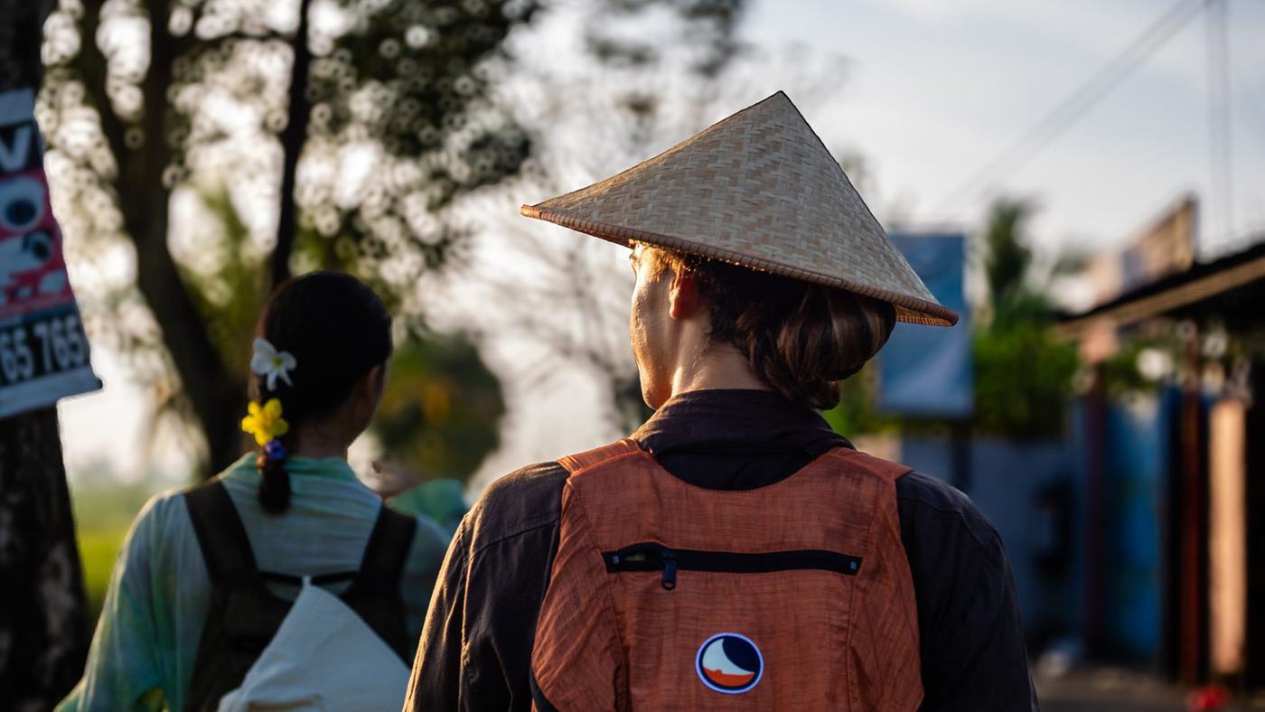 A pilgrim in a woven farmer's hat on a village road